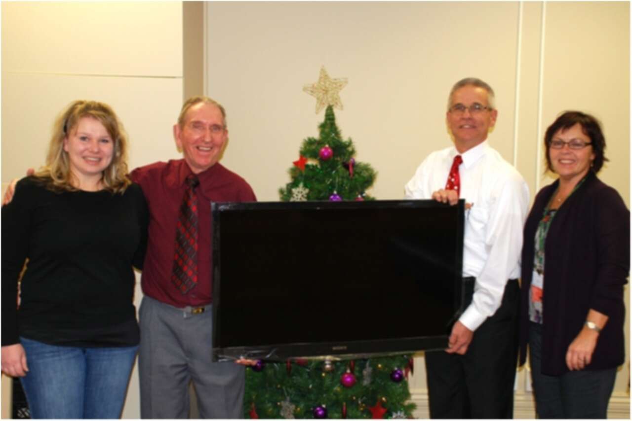 Two men holding donated TV