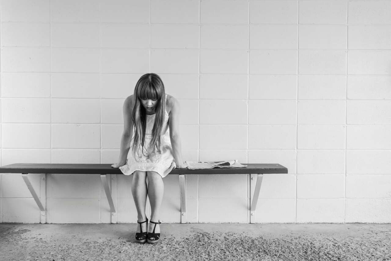 Canva Grayscale Photo Of Girl Sitting On Bench Near Wall